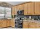 Well-lit kitchen boasts stainless appliances, granite countertops, mosaic backsplash, and wood cabinetry at 9702 E Naranja Ave, Mesa, AZ 85209