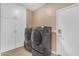 Functional laundry room with modern washer and dryer, complemented by ample storage cabinets for organization at 9702 E Naranja Ave, Mesa, AZ 85209