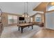 Open-concept living room featuring a billiards table, plush seating, and ample natural light at 9702 E Naranja Ave, Mesa, AZ 85209