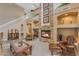 Bright living room with a stone fireplace, a white staircase, and views of the upstairs balcony at 9702 E Naranja Ave, Mesa, AZ 85209