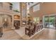 Cozy living room featuring a floor-to-ceiling stone fireplace and views of the backyard pool at 9702 E Naranja Ave, Mesa, AZ 85209