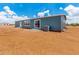 Exterior view of the house showing sliding glass door, windows, and an AC unit in a vast dirt yard at 10150 E Shallow Canyon Rd, San Tan Valley, AZ 85143