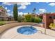 Community hot tub with blue tile and accessible handrail, surrounded by vibrant flowering shrubs at 10301 N 70Th St # 223, Paradise Valley, AZ 85253