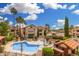 Community pool surrounded by residential buildings, mature landscaping, and lounge chairs at 10301 N 70Th St # 223, Paradise Valley, AZ 85253