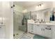 Bright bathroom featuring a glass shower and vanity with white cabinets and modern fixtures at 10545 E Texas Ave, Mesa, AZ 85212