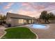 Private backyard featuring a swimming pool, lush green lawn, mature trees, and a serene atmosphere for outdoor enjoyment at 10760 W Encanto Blvd, Avondale, AZ 85392