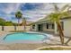 Backyard featuring a refreshing kidney-shaped pool, low maintenance yard, covered patio and palm trees at 10760 W Encanto Blvd, Avondale, AZ 85392