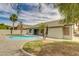 Backyard featuring a refreshing kidney-shaped pool, low maintenance yard, grassy area and mature palm trees at 10760 W Encanto Blvd, Avondale, AZ 85392