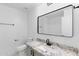 Modern bathroom with a granite countertop, black hardware, and a framed mirror at 10760 W Encanto Blvd, Avondale, AZ 85392
