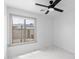 Bright bedroom featuring marble-look tile floor, ceiling fan, and large window with view to backyard at 10760 W Encanto Blvd, Avondale, AZ 85392