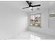 Sun-drenched bedroom featuring marble floors, a ceiling fan, and a large window at 10760 W Encanto Blvd, Avondale, AZ 85392