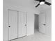Bright bedroom featuring marble-look tile floor, ceiling fan, closet, and interior door to attached space at 10760 W Encanto Blvd, Avondale, AZ 85392