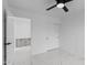 Bright bedroom featuring marble-look tile floor, ceiling fan, closet and interior door to attached space at 10760 W Encanto Blvd, Avondale, AZ 85392