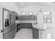 Modern kitchen with stainless steel appliances, granite countertops, and gray cabinets, perfect for cooking and entertaining at 10760 W Encanto Blvd, Avondale, AZ 85392