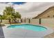 Backyard featuring a refreshing kidney-shaped pool, low maintenance yard, block wall, and palm trees at 10760 W Encanto Blvd, Avondale, AZ 85392