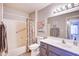Bright bathroom featuring a shower-tub combo with floral curtains and a vanity with gray cabinets at 11069 E Kilarea Ave # 194, Mesa, AZ 85209