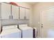 Functional laundry room with white washer, dryer, and ample cabinet storage above at 11069 E Kilarea Ave # 194, Mesa, AZ 85209