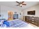 Main bedroom with a large bed, ceiling fan, and access to ensuite bathroom at 11069 E Kilarea Ave # 194, Mesa, AZ 85209
