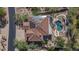 Home with tile roof and solar panels is surrounded by desert landscaping and an ornate backyard pool at 11446 E Sweetwater Ave, Scottsdale, AZ 85259