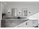 Bright bathroom features dual sinks, gray cabinetry, stone countertops and decorative mirrors at 11446 E Sweetwater Ave, Scottsdale, AZ 85259