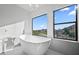Bright bathroom with sleek soaking tub, natural light, and beautiful outdoor views at 11446 E Sweetwater Ave, Scottsdale, AZ 85259