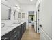 Hall bathroom featuring dual sinks, quartz countertops and white cabinets with a view to the bedroom at 11446 E Sweetwater Ave, Scottsdale, AZ 85259