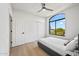 Bright bedroom with a ceiling fan, arched window with a view, and closet at 11446 E Sweetwater Ave, Scottsdale, AZ 85259