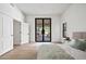 Bright bedroom offering wood floors, a modern bed, and double doors to the outdoor space at 11446 E Sweetwater Ave, Scottsdale, AZ 85259