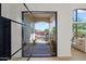 Inviting entryway featuring modern glass door, manicured landscaping, and walkway to the house at 11446 E Sweetwater Ave, Scottsdale, AZ 85259
