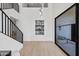 Bright foyer with staircase, light wood floors, niche with bar, and modern glass door at 11446 E Sweetwater Ave, Scottsdale, AZ 85259