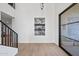Bright foyer with staircase, light wood floors, niche with bar, and modern glass door at 11446 E Sweetwater Ave, Scottsdale, AZ 85259