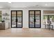 Bright living room boasting wood floors, modern light fixture and black french doors to the outdoor space at 11446 E Sweetwater Ave, Scottsdale, AZ 85259