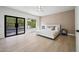 This bright main bedroom features neutral tones, wood floors, and sliding glass doors to a balcony at 11446 E Sweetwater Ave, Scottsdale, AZ 85259