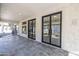 Covered patio with spiral staircase, slate tile flooring and entry to home with dark-trimmed doors and windows at 11446 E Sweetwater Ave, Scottsdale, AZ 85259