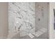 Modern walk-in shower features gorgeous marble-style tiles and shower head at 11446 E Sweetwater Ave, Scottsdale, AZ 85259