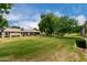 Manicured backyard featuring lush green grass and mature trees at 13015 W Blue Sky Dr, Sun City West, AZ 85375