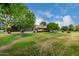 Lush backyard featuring well-maintained lawn, mature trees, and serene landscape at 13015 W Blue Sky Dr, Sun City West, AZ 85375