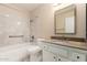 Bright bathroom with shower and tub combination and a granite vanity top at 13015 W Blue Sky Dr, Sun City West, AZ 85375