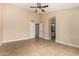 Neutral bedroom with ceiling fan, tile floor and an en-suite bathroom at 13015 W Blue Sky Dr, Sun City West, AZ 85375