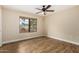 Bedroom with modern ceiling fan, wood floors and a window overlooking the front yard at 13015 W Blue Sky Dr, Sun City West, AZ 85375