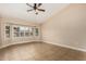 Open bedroom features a ceiling fan and a bay window with white shutters allowing ample natural light at 13015 W Blue Sky Dr, Sun City West, AZ 85375