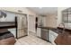 Bright kitchen features stainless steel appliances, tile floors and backsplash, and modern white cabinets at 13015 W Blue Sky Dr, Sun City West, AZ 85375
