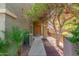 Inviting entryway featuring a wooden door, manicured plants, and a well-maintained walkway at 13540 N 87Th Dr, Peoria, AZ 85381