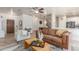 Open-concept living room with comfortable seating, herringbone floors, and a seamless flow to dining and kitchen areas at 13540 N 87Th Dr, Peoria, AZ 85381