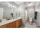 Well-lit bathroom with a wood vanity, dual lights, a large mirror, and neutral finishes for a clean and refreshing space at 14417 N 151St Dr, Surprise, AZ 85379