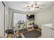Home gym with an exercise bike, a treadmill, a wall-mounted TV, and natural light from a window at 14417 N 151St Dr, Surprise, AZ 85379