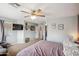View of main bedroom featuring ceiling fan, TV, carpet floors and entry into the main bathroom at 14417 N 151St Dr, Surprise, AZ 85379
