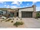 Charming single-story home featuring desert landscaping, a brick chimney, and a modern garage door at 14551 N Adero Canyon Dr, Fountain Hills, AZ 85268