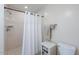 Tiled walk-in shower with white shower curtain and vanity storage at 14627 N 55Th Pl, Scottsdale, AZ 85254