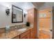 Bathroom with granite countertop and sink, sconce lighting and access to toilet at 14627 N 55Th Pl, Scottsdale, AZ 85254